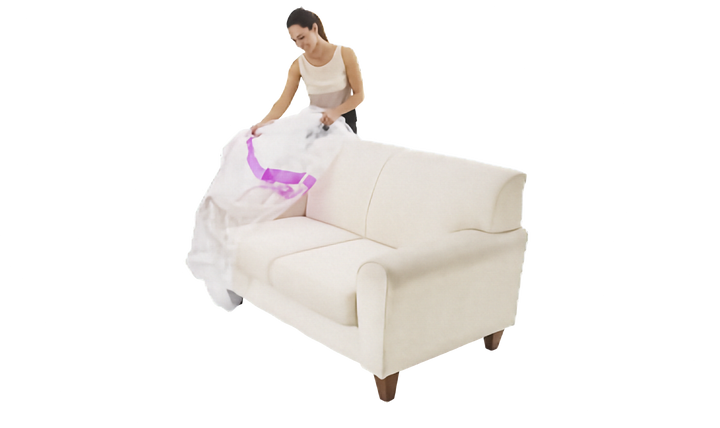 A woman in a white tank top and dark pants is covering a white fabric sofa with a plastic lounge cover with pink stripe, shown on a solid white background.