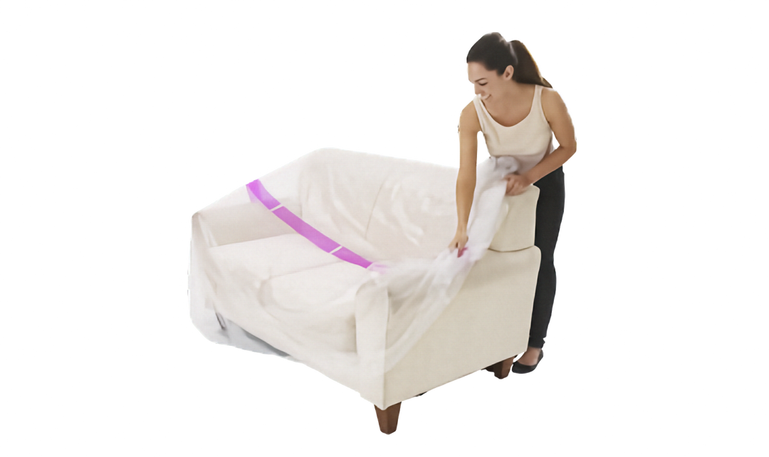 A woman is shown wrapping a clear plastic protective couch cover with a pink stripe around a cream-colored armchair against a solid white background.