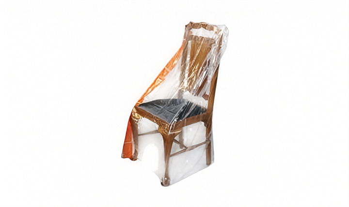 A wooden dining chair with a black seat cushion, wrapped in a clear plastic protective cover, shown against a plain white background.